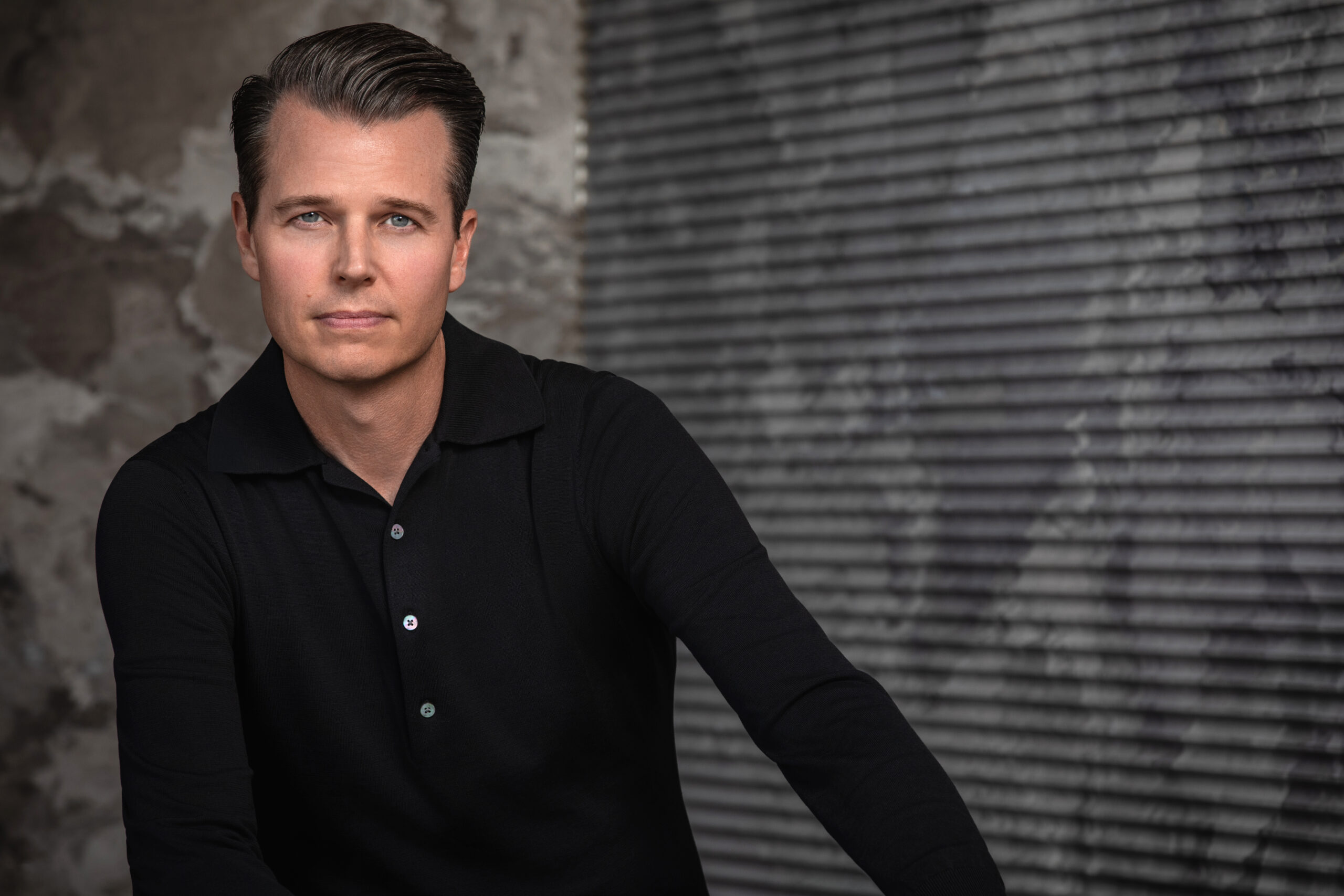 Portrait of Jeffrey Florentine of JSF Design in front of textured stone surfaces from the Elementa collection created in collaboration with Antolini Stone.